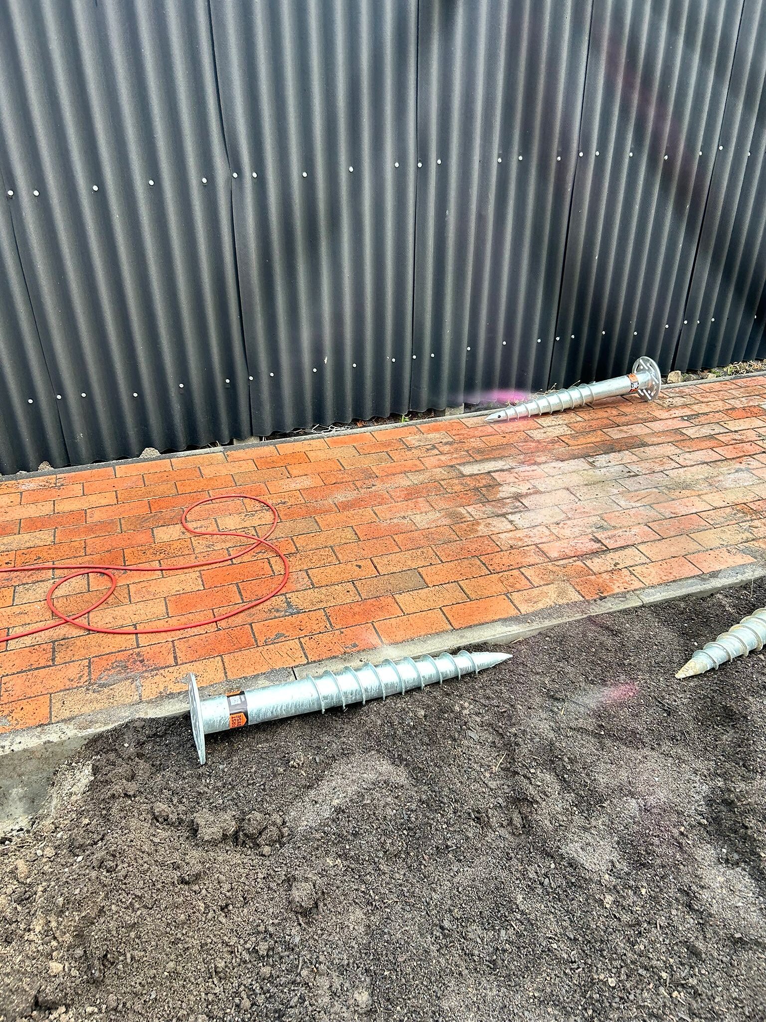 Schrauben für das Fundament liegen auf dem Boden bereit.